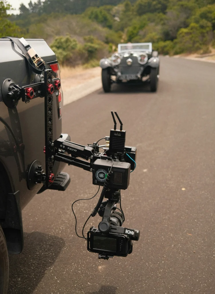 “FPV drone filming high-speed car chase sequence for automotive video production.”
